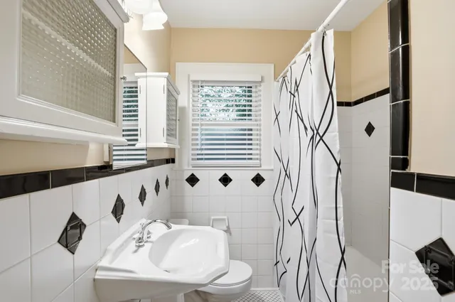 a bathroom with a sink and mirror with bathtub