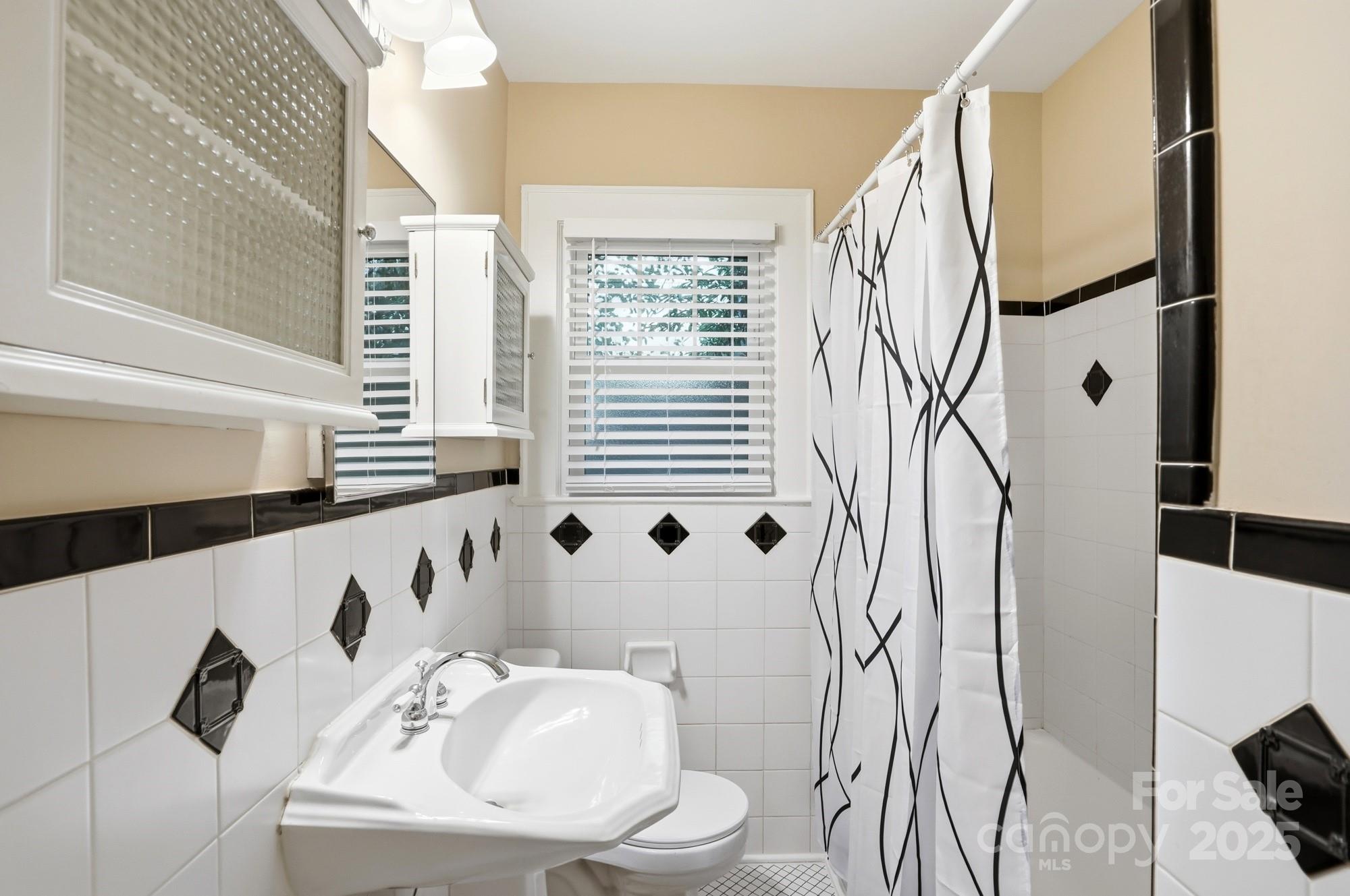 3108 Westmoreland Avenue Charlotte, NC 28205 - Photo 16 of 27 a bathroom with a sink and mirror with bathtub