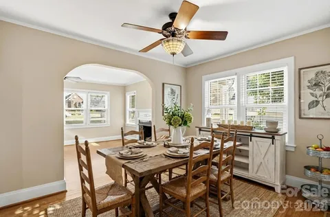 a view of a dining room and livingroom with furniture wooden floor and a chandelier