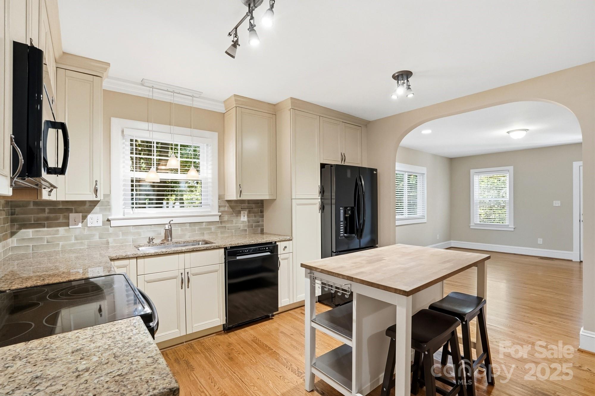 3108 Westmoreland Avenue Charlotte, NC 28205 - Photo 7 of 27 a kitchen with a table chairs refrigerator and microwave