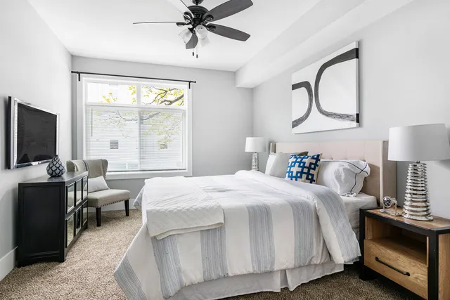 a bedroom with a large bed and a flat tv screen on dresser