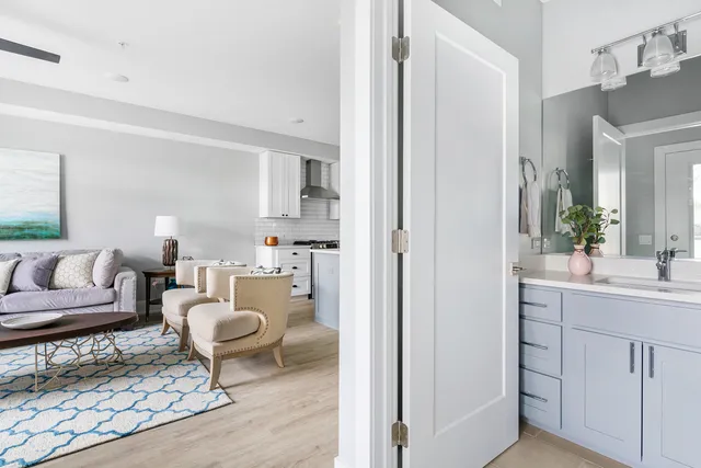 a living room with furniture a rug and a mirror