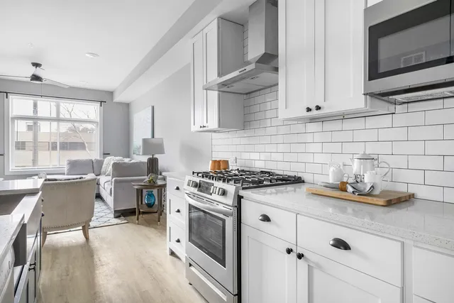 a kitchen with cabinets wooden floor and a stove top oven