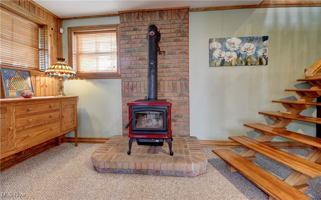 85530 Beagle Club Road Scio, OH 43988 - Photo 27 of 49 Living room with a wood stove, carpet flooring, ornamental molding, baseboards, and stairway