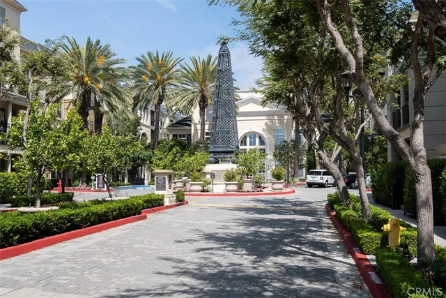 a front view of a house with fountain and garden
