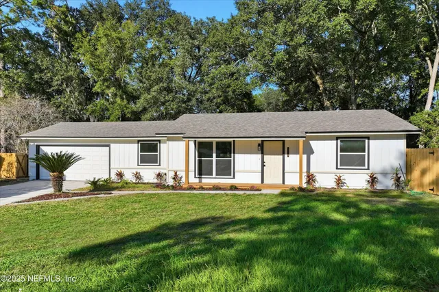 a front view of a house with a yard and trees