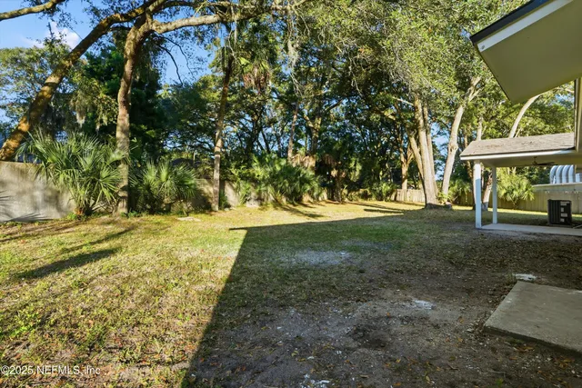 an aerial view of a house with a yard and large trees