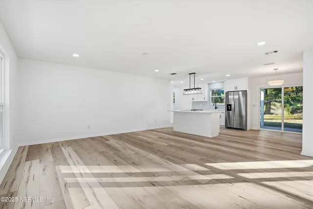 a kitchen with stainless steel appliances kitchen island hardwood floor sink stove and refrigerator