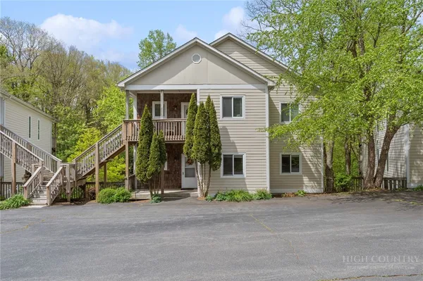 a view of a house and a yard and tree s