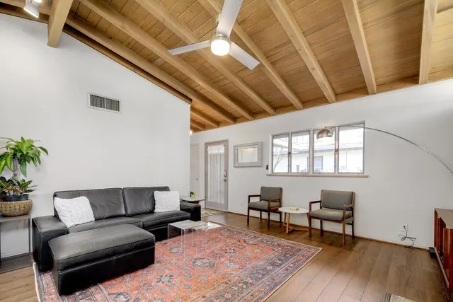 a living room with furniture and wooden floor
