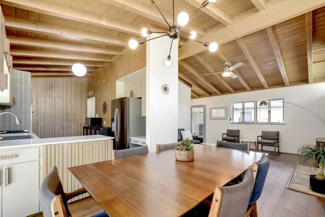 a kitchen with a table chairs refrigerator and cabinets