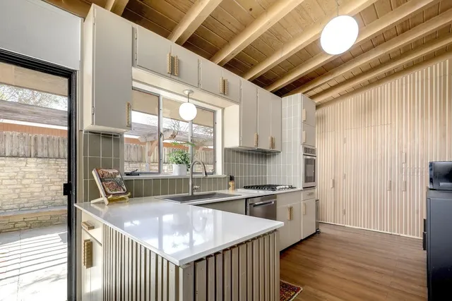 a kitchen with stainless steel appliances granite countertop a sink a oven and a refrigerator