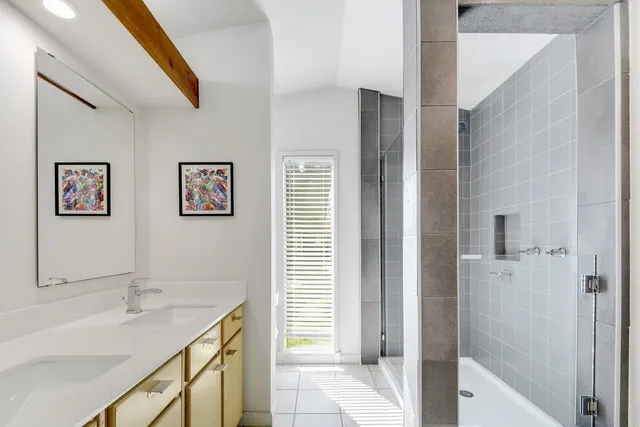 a bathroom with a granite countertop sink a mirror a vanity and a shower