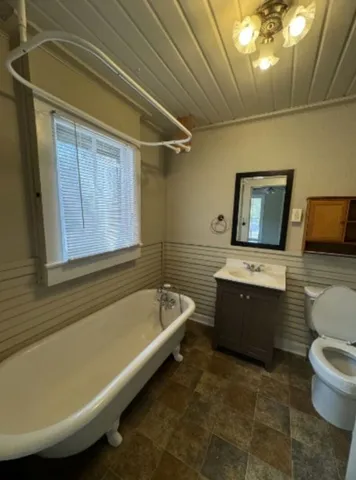 a bathroom with a granite countertop sink a toilet and bathtub
