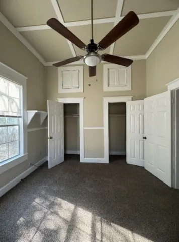 a view of empty room with windows and ceiling fan