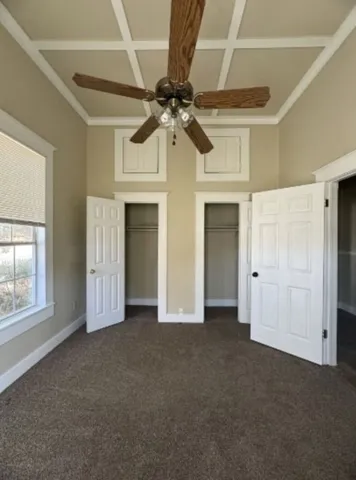 a view of empty room with windows and ceiling fan