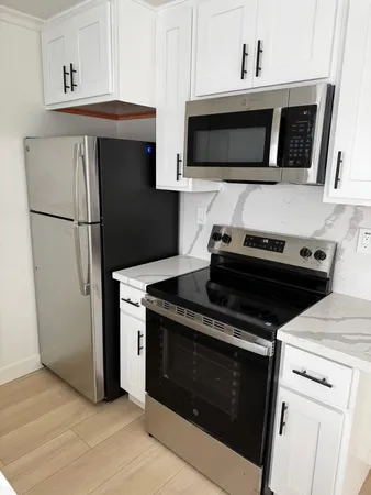 a kitchen with stainless steel appliances a stove a microwave a sink and cabinets