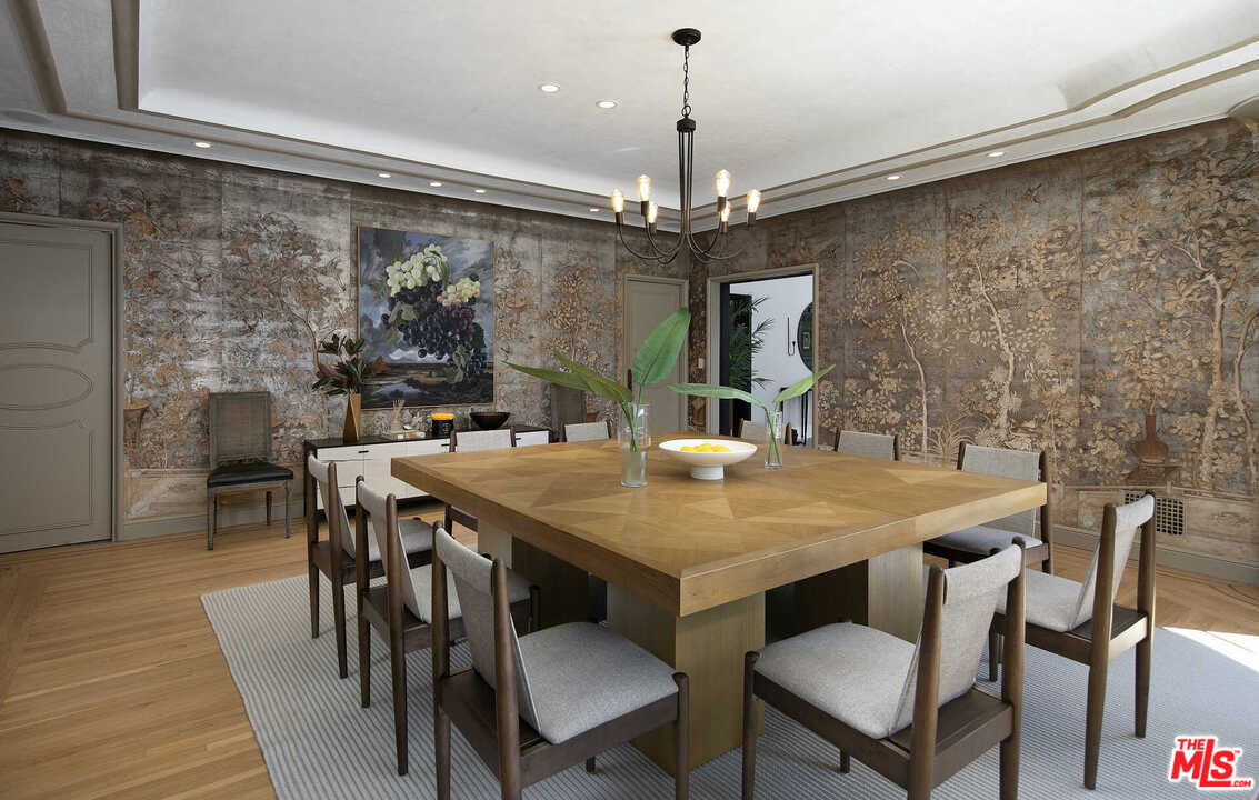 910 North Rexford Drive Beverly Hills, CA 90210 - Photo 9 of 32 a view of a dining room with furniture a chandelier and wooden floor