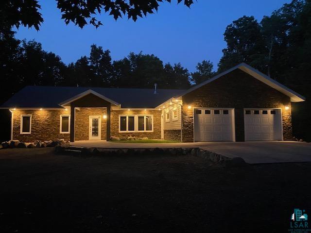 5669 Park Hill Road Finland, MN 55603 - Photo 44 of 46 View of front facade featuring stone siding, concrete driveway, and a garage