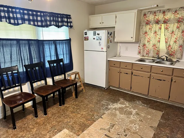 a kitchen with stainless steel appliances granite countertop a sink refrigerator and cabinets