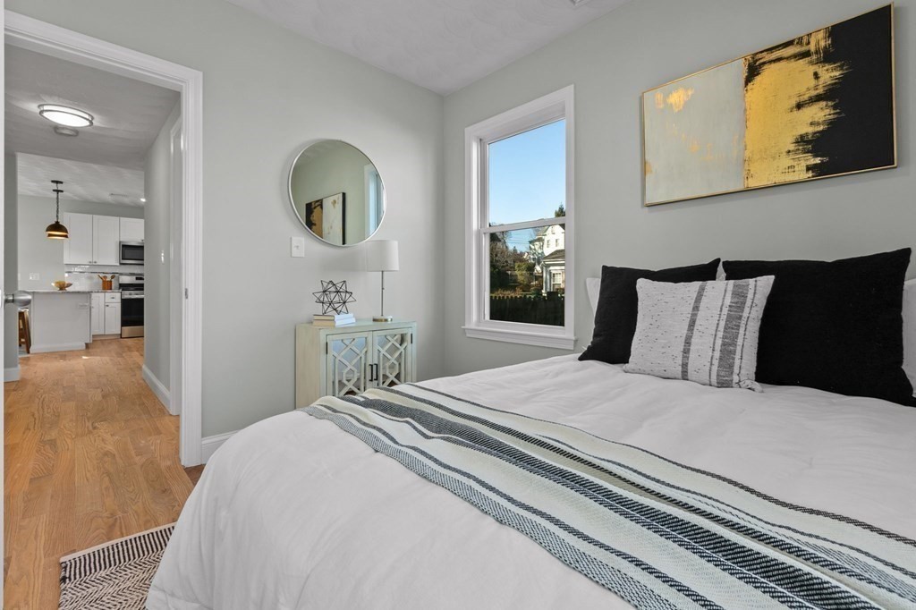 57 Buffum Street, Unit 1 Salem, MA 01970 - Photo 13 of 31 a bedroom with a bed mirror and painting on the wall