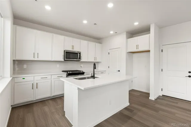 a kitchen with stainless steel appliances granite countertop a stove a sink and a refrigerator