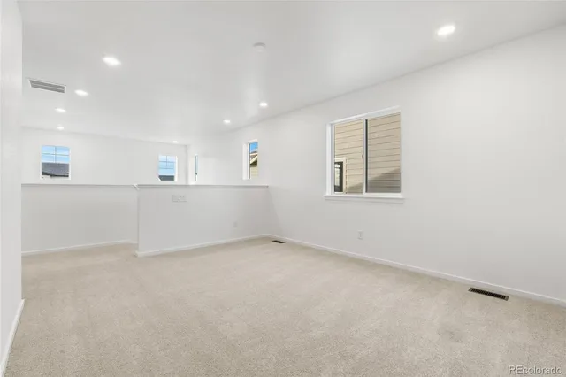 an empty room with white walls and windows