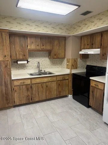 a kitchen with a sink a stove and cabinets