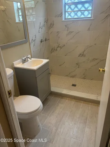 a white toilet sitting next to a bath tub