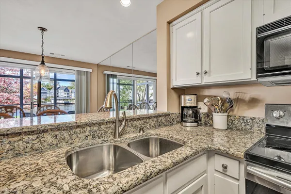 a kitchen with granite countertop a sink stove and cabinets
