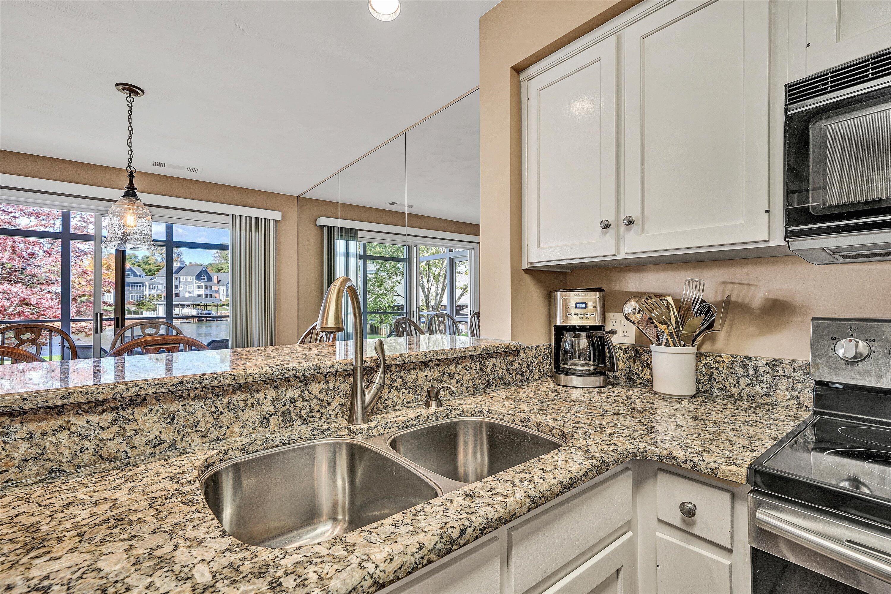 410 Marina Bay Drive, Unit 102 Penhook, VA 24137 - Photo 16 of 38 a kitchen with granite countertop a sink stainless steel appliances and cabinets