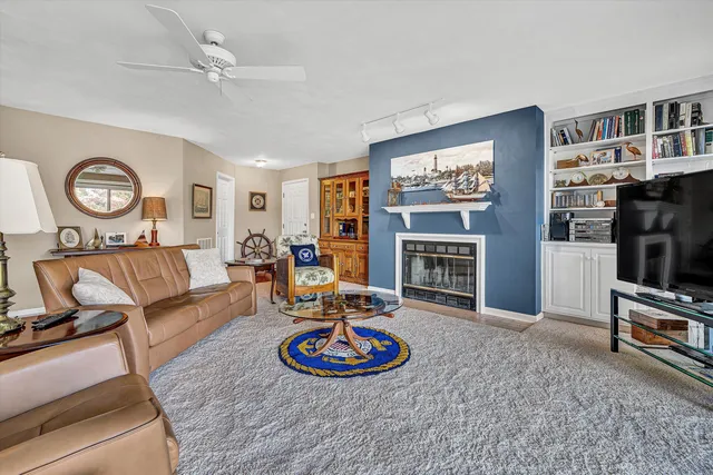 a living room with furniture a flat screen tv and a large window