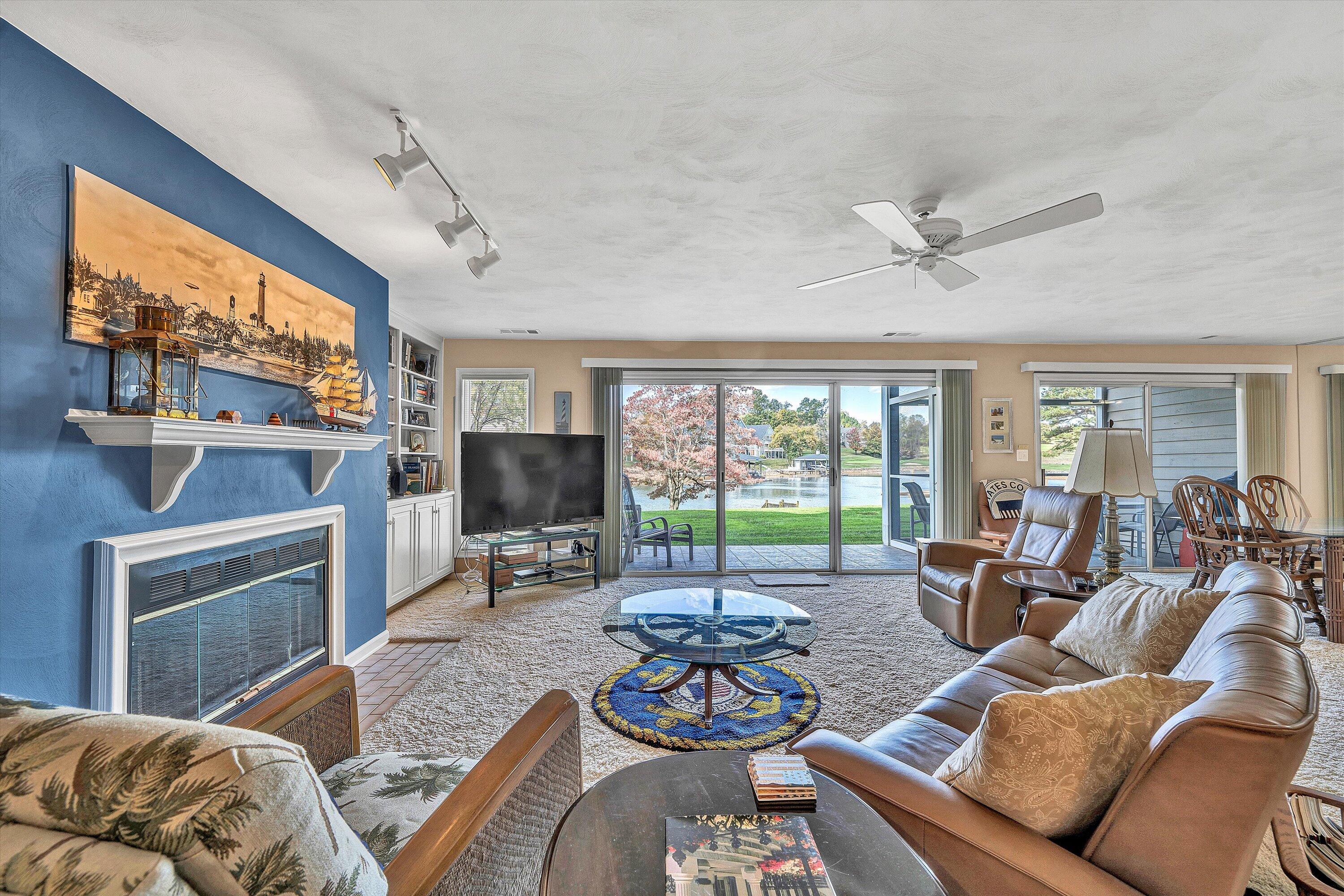 410 Marina Bay Drive, Unit 102 Penhook, VA 24137 - Photo 8 of 38 a living room with furniture a flat screen tv and a large window