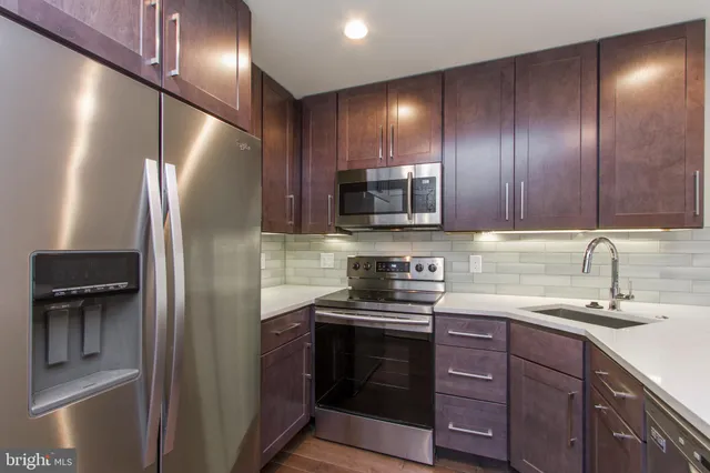 a kitchen with stainless steel appliances granite countertop a refrigerator and a sink