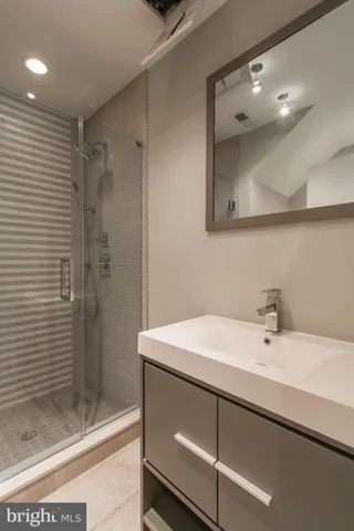 a bathroom with a sink a shower and a mirror