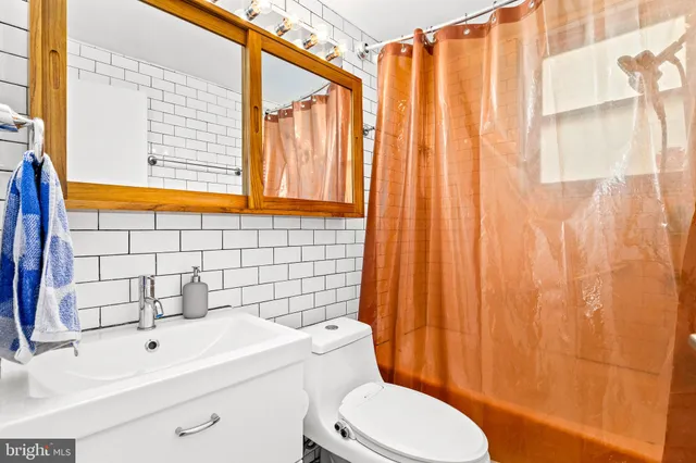 a bathroom with a sink a toilet and shower curtain