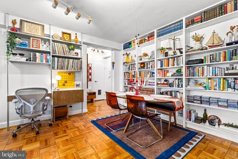a living room with furniture a rug and a book shelf