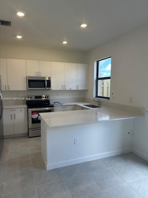 11781 Southwest 245 Terrace, Unit 11781 Homestead, FL 33032 - Photo 2 of 14 a kitchen with granite countertop a stove sink and cabinets