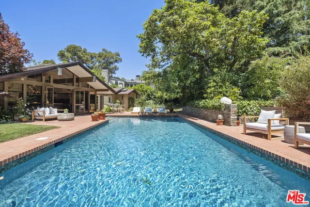 a view of a house with swimming pool and sitting area