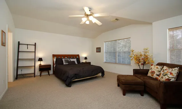a bedroom with a bed couch and a window