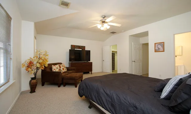 a bedroom with furniture and a flat screen tv