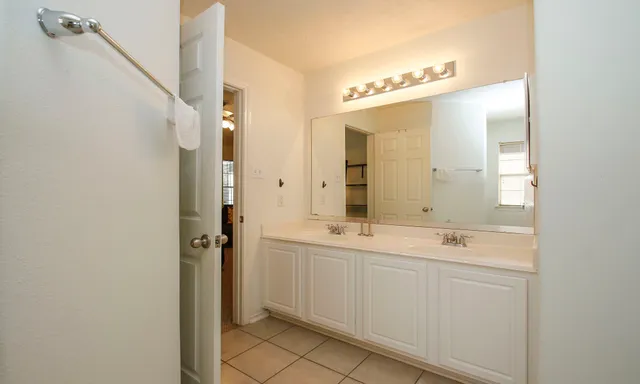 a bathroom with a double vanity sink mirror and shower