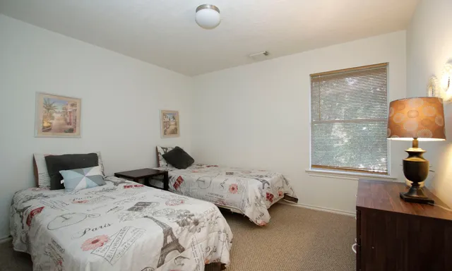 a bedroom with two beds and a lamp