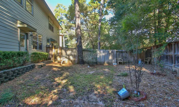 a view of a backyard with table and chairs and wooden fence