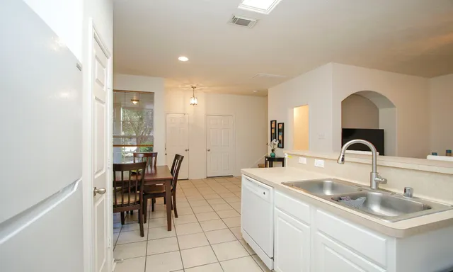 a kitchen with sink a table and chairs