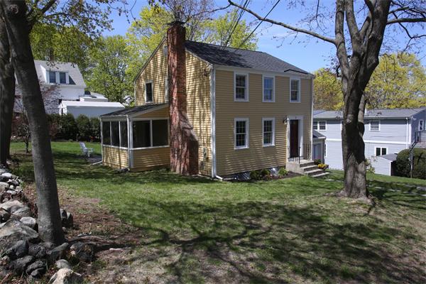 7 Sutherland Road Lexington, MA 02421 - Photo 2 of 22 a view of a yard in front of a house with plants and large tree