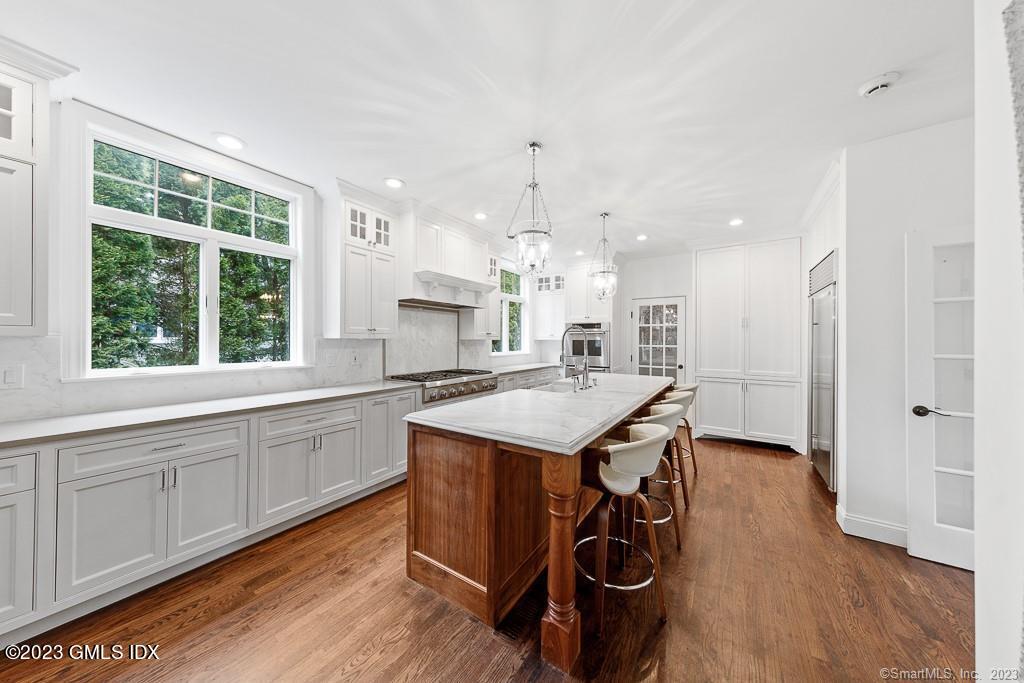 5 Miller Road Darien, CT 06820 - Photo 12 of 40 a kitchen with a sink a stove a refrigerator and white cabinets with wooden floor