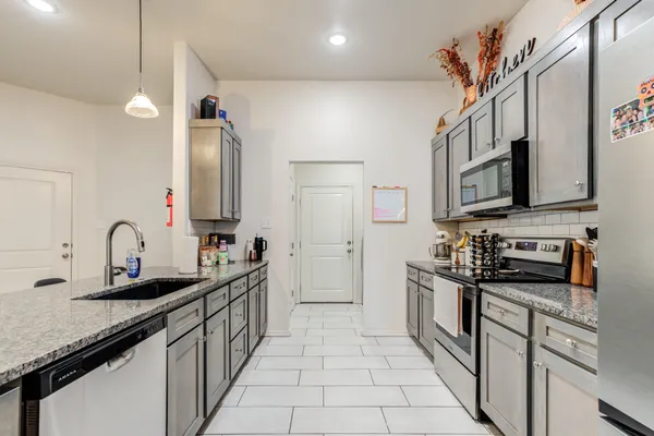 a kitchen with stainless steel appliances granite countertop a sink stove and cabinets