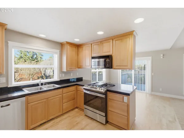 a kitchen with kitchen island granite countertop a sink cabinets and stainless steel appliances
