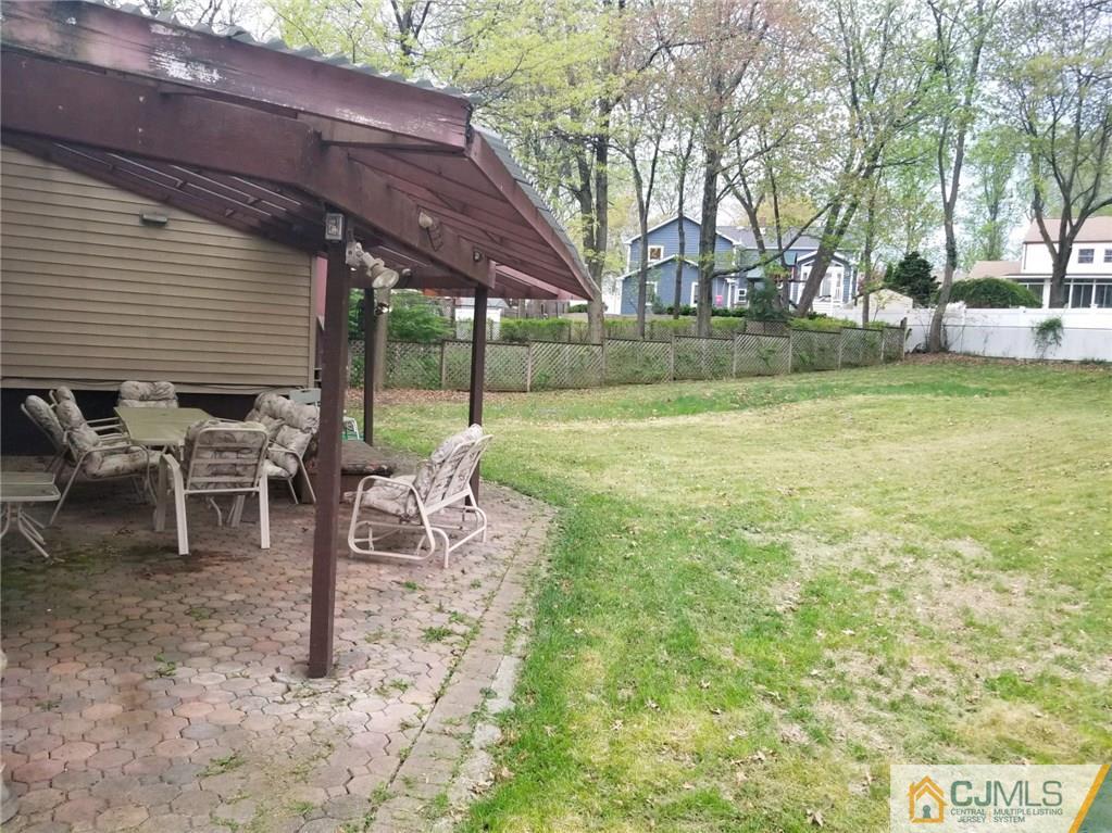 18 Hill Road Edison, NJ 08817 - Photo 12 of 13 a view of a patio with table and chairs and floor to ceiling window